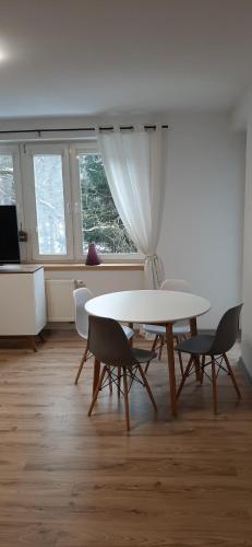 een eetkamer met een tafel en stoelen en een raam bij Apartament OLIVER in Świnoujście