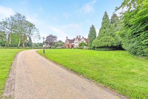 Exquisite Manor House in Surrey Hills في Lower Kingswood: طريق حصى أمام المنزل