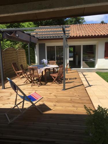 un patio con mesa, sillas y sombrilla en gîte au Pays Basque entre mer et montagne en Villefranque