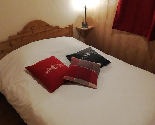 Una cama blanca con dos almohadas. en Rez de chaussée très calme vue Mont-Blanc en Combloux