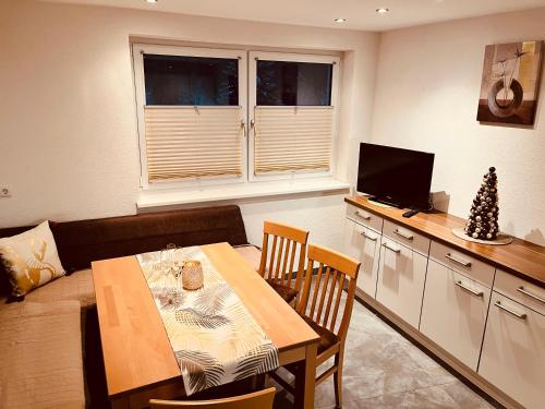 a living room with a dining table and a television at Ferienwohnung Petter in See
