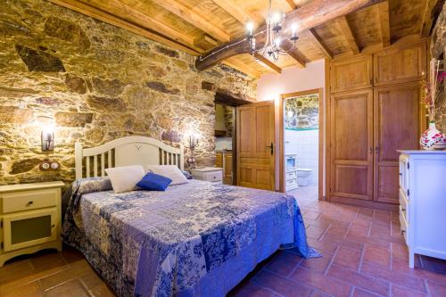 a bedroom with a bed and a stone wall at A casa de López in A Coruña