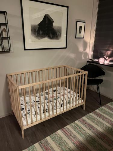 - un lit bébé dans une chambre avec une photo sur le mur dans l'établissement Cosy Harbour Apartment, à Reykjavik