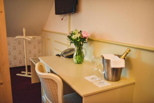 a table with a vase of flowers on it at Zámek Kamenný Dvůr in Kynšperk nad Ohří