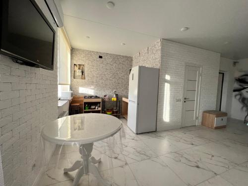 uma cozinha com uma mesa branca e um frigorífico em New Marine Apartment em Yuzhne