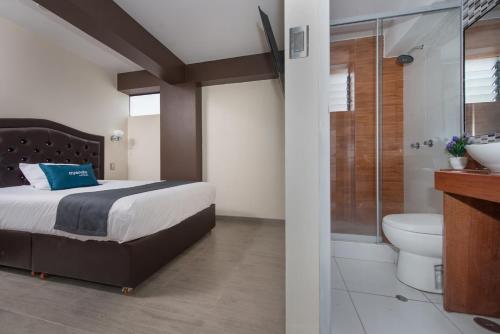 1 dormitorio con cama, ducha y aseo en Olimpo Hotel Sauna & Spa, en Cusco