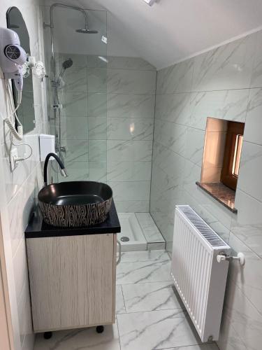 a bathroom with a sink and a shower at Casa La Bella Vista in Moisei