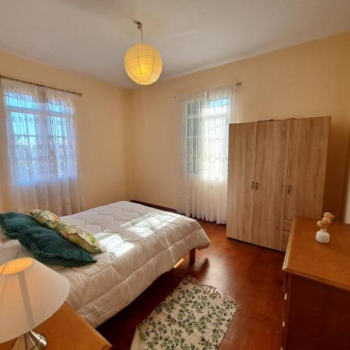 a bedroom with a bed and a chandelier at Chalé Funchal - City view in Funchal