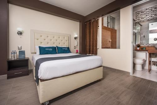 1 dormitorio con 1 cama grande con almohadas azules en Olimpo Hotel Sauna & Spa, en Cusco