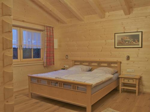 a bedroom with a bed in a log cabin at Ferienwohnungen Bauregger - Chiemgau Karte in Inzell