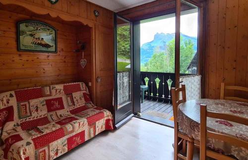 a room with a bed and a table and a window at Alpenrose Saint Gervais les Bains in Saint-Gervais-les-Bains