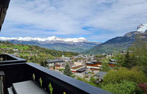 a view from a balcony of a town with snow capped mountains at Alpenrose Saint Gervais les Bains in Saint-Gervais-les-Bains