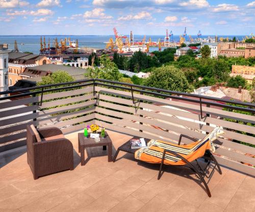 a balcony with a bench and a table and chairs at Continental Hotel in Odesa