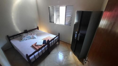 ein kleines Schlafzimmer mit einem Bett und einem Fenster in der Unterkunft Eco-Residencial Martins in Apiaí