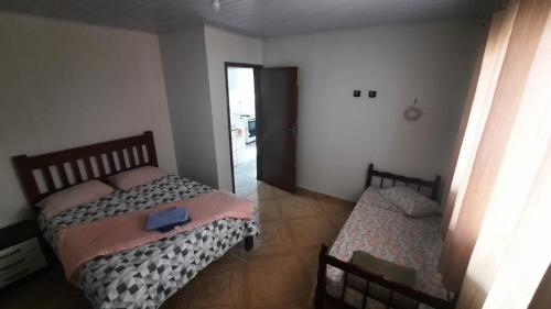 a bedroom with two beds and a door to a hallway at Eco-Residencial Martins in Apiaí
