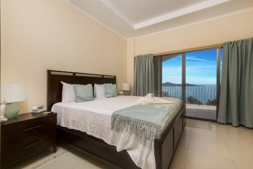 ein Schlafzimmer mit einem großen Bett und einem großen Fenster in der Unterkunft Playa Flamingo, Stunning Sunset View Condominium Flamingo Towers 17 in Playa Flamingo