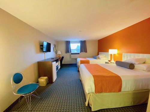 a hotel room with two beds and a television at Howard Johnson by Wyndham Gravenhurst in Gravenhurst