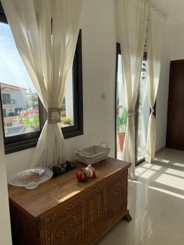 Habitación con mesa de madera y ventanas en Beautiful and modern apartment in Oroklini Cyprus, en Oroklini
