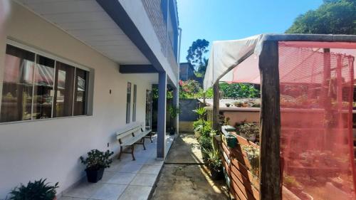a porch of a house with a bench and plants at Eco-Residencial Martins in Apiaí