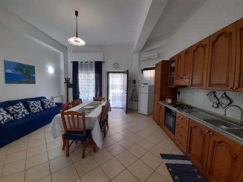 eine Küche und ein Wohnzimmer mit einem Tisch und einem Sofa in der Unterkunft Radici Blu intero alloggio in Siderno Marina