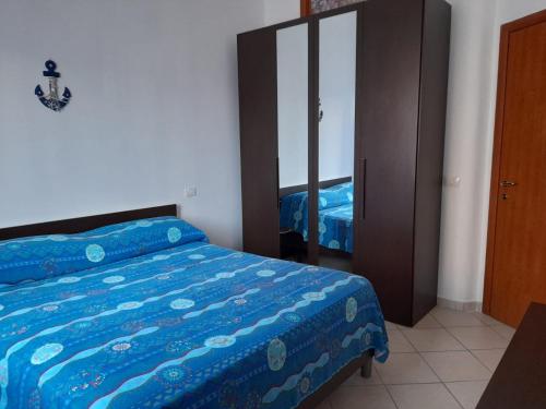 una camera con letto blu e specchio di Radici Blu intero alloggio a Siderno Marina