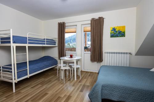 a bedroom with two bunk beds and a table at Chata Muszyna in Muszyna