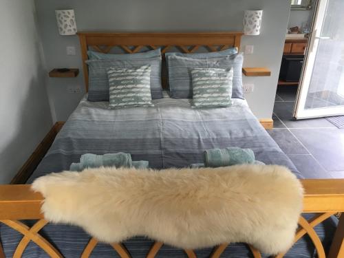 Un dormitorio con una cama con una alfombra peluda. en Trewethen Cottage Barn 1 near Port Isaac, en Port Isaac