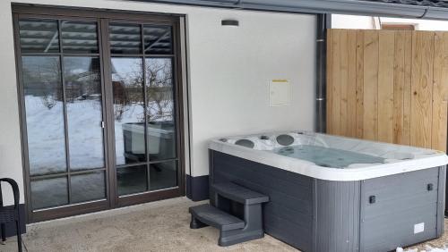 une baignoire jacuzzi dans une chambre avec fenêtres dans l'établissement Pr `Agotnik Apartments & Rooms Bohinj, à Bohinj