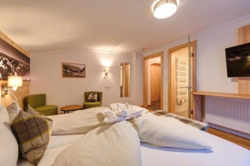 a hotel room with two beds and a television at Hotel Enzian Paznaun in See
