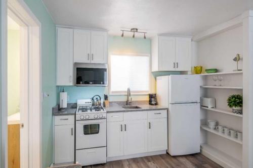 a kitchen with white cabinets and a white refrigerator at Beachside Inn in Seaside