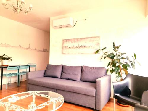 a living room with a purple couch and a table at TOLETUM low cost LOFTS diáfanos o 2dormitorios PARKING Municipal Gratis al aire libre a 100m in Toledo