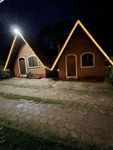 a house with a light on the roof at night at Pousada Vale Verde in Monte Verde