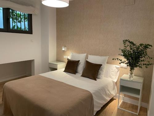 um quarto com uma grande cama branca e 2 almofadas em Apartamentos Cisneros em Alicante