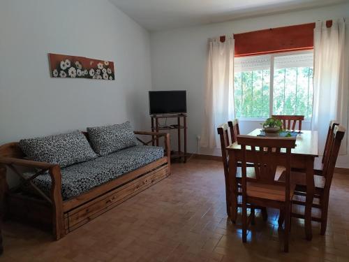 sala de estar con sofá y mesa en CHALET NATURALEZA - Villa Rumipal - Córdoba - A 50 mts del Lago - Vista al Lago en Villa Rumipal