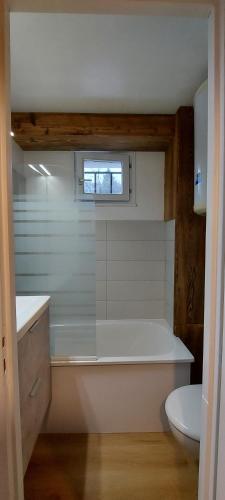une salle de bain avec baignoire et toilettes et une fenêtre dans l'établissement La Belette, à Gérardmer