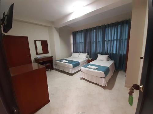 a hotel room with two beds and a window at Hotel El Andino in Cúcuta