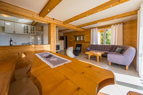 uma sala de estar com uma grande mesa de madeira num quarto em Solna Chata-dom na wyłączność Grota solna, balia, sauna, basen em Rajcza