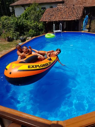 three boys in an inflatable raft in a swimming pool at Lozanski ambar in Boljevac