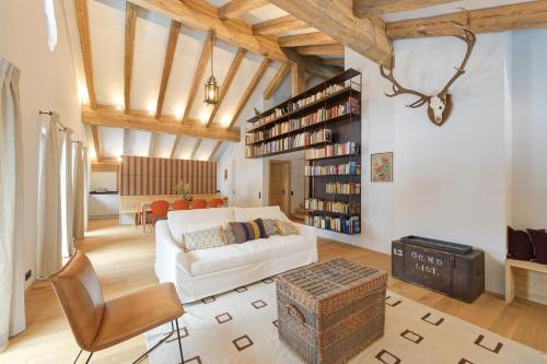 een woonkamer met een witte bank en een boekenplank bij Chalet SILVER FOX - Luxus Chalets in Sankt Anton am Arlberg