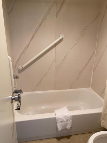 a white bath tub in a bathroom with a toilet at King's Inn Motel in Reading