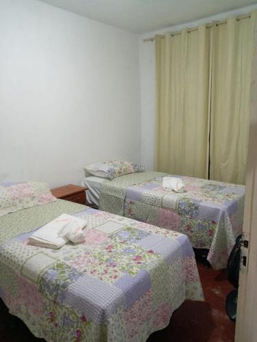 a room with three beds with towels on them at Aconchego em Garanhuns in Garanhuns