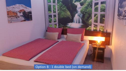 a bedroom with a bed with red cushions and windows at Superb view+Swim Pool+Smart TV+Netflix+Projector in LʼHuez