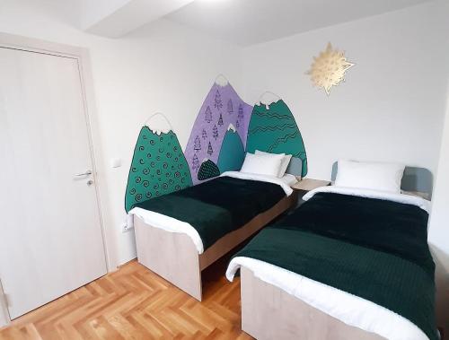 1 dormitorio con 2 camas con sábanas verdes y azules en 1000mnv, en Palisat