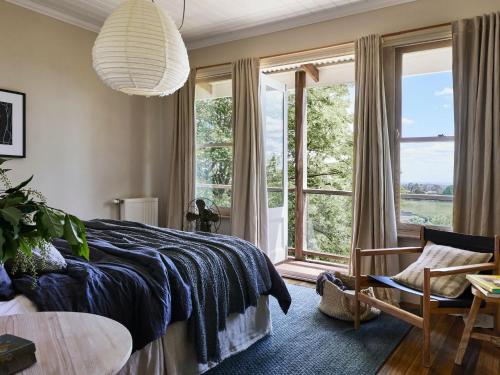 a bedroom with a bed and a large window at Milk and Honey in Daylesford