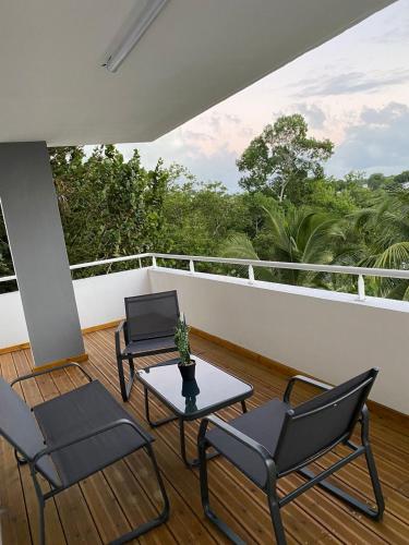 - une terrasse couverte avec 2 chaises et une table sur un balcon dans l'établissement L'Appart, à Les Abymes