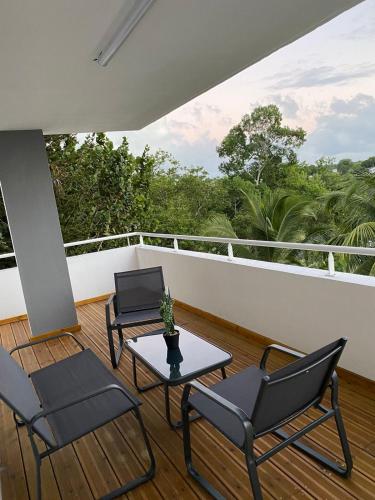 un portico con 2 sedie e un tavolo sul balcone di L'Appart a Les Abymes