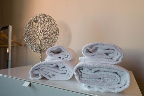 a pile of towels sitting on a glass table at SLEEP & FLY Bergamo Centro in Bergamo
