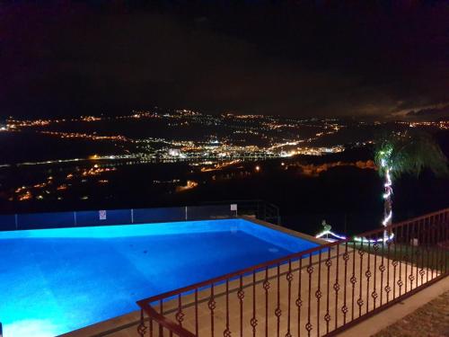 a swimming pool with a view of a city at night at Golden Mirror in Lamego