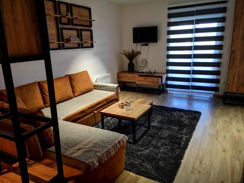 a living room with a couch and a coffee table at Apartman Mali Raj Zlatar in Nova Varoš