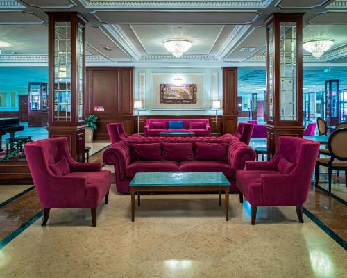 a living room with a couch and two chairs at Radisson Hotel Astana in Astana